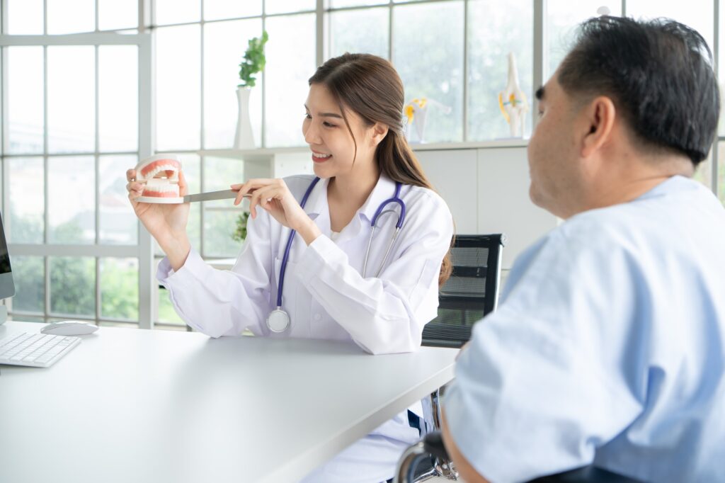 A dentist explains a situation involving oral and dental therapy to a patient.