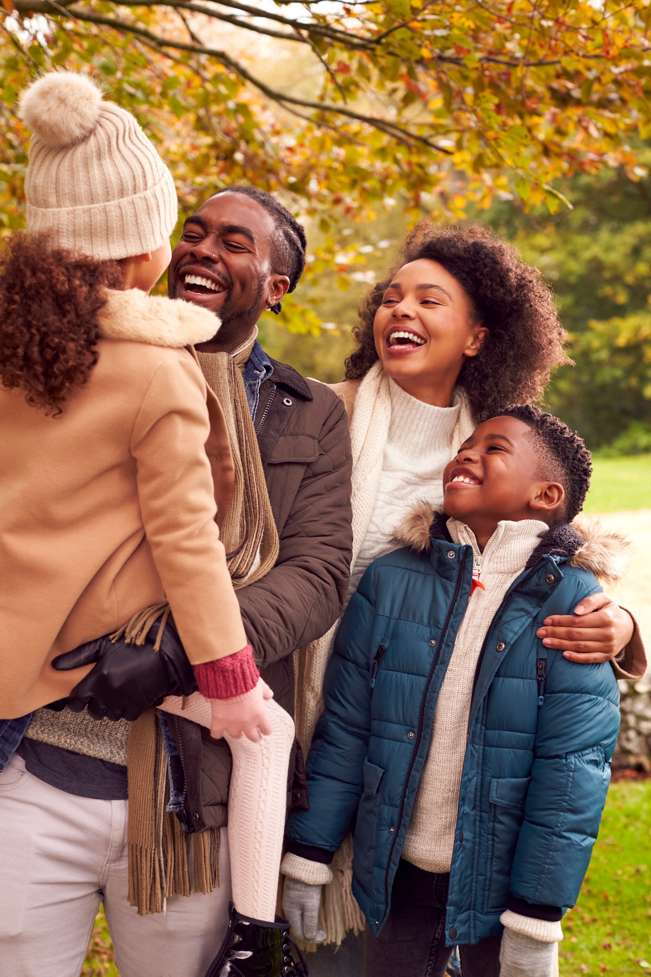 Smiling Family On Walk Through Countryside Against Autumn Trees