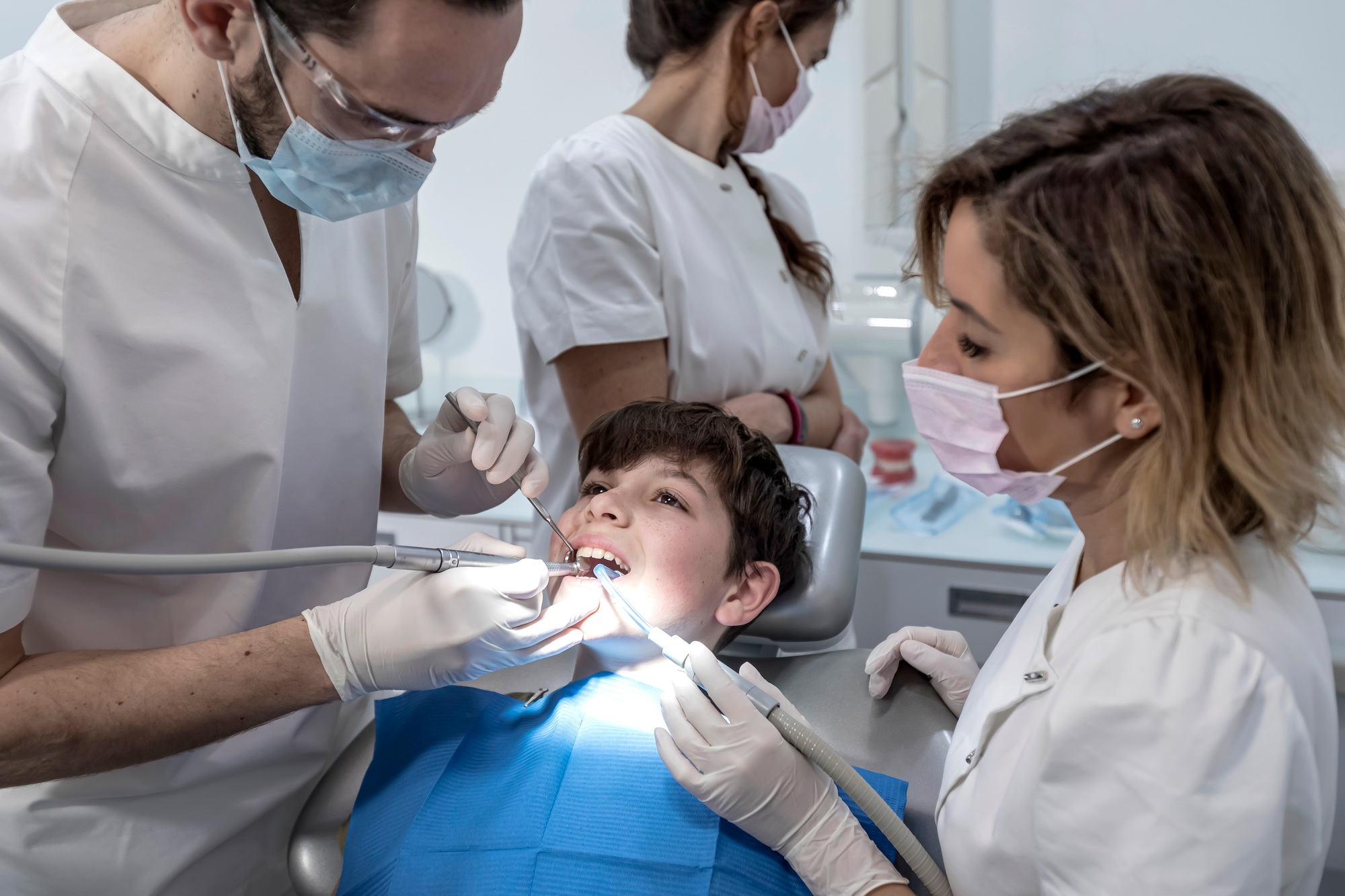 Team of dentists treating a young boy for orthodontics in the dentist's clinic