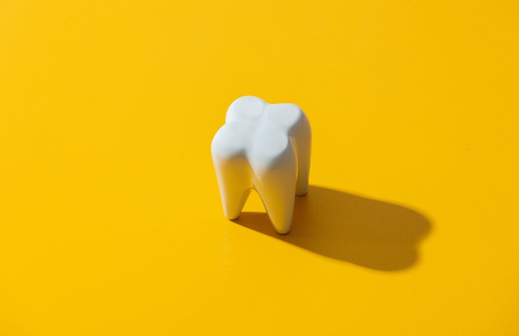 big white tooth on yellow background